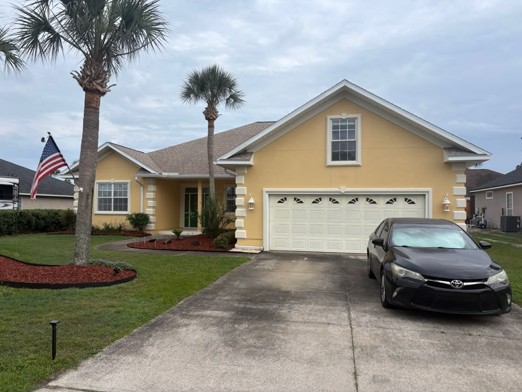 Stucco home exterior after — cleaned and repainted with a fresh, even finish